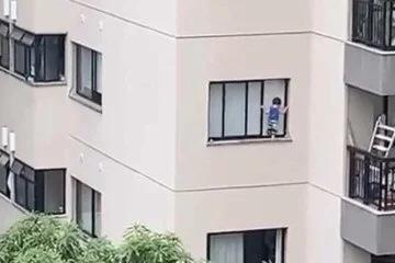 Criança fica pendurada em janela de prédio e desespera moradores; assista