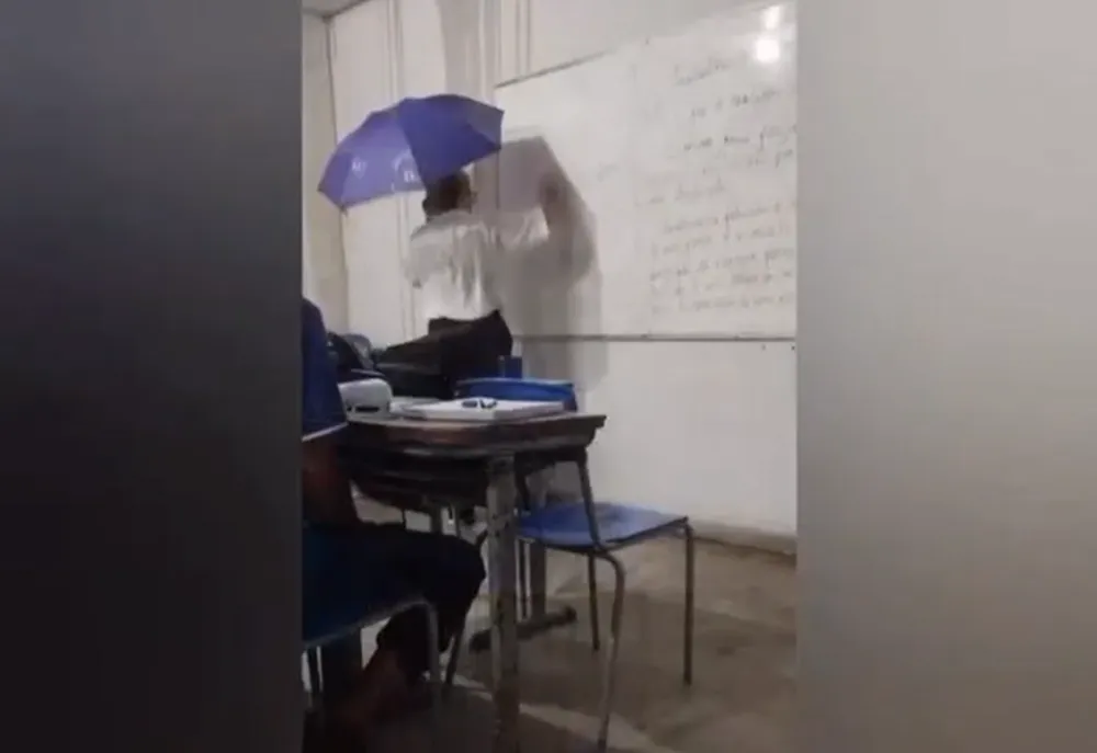 Professora usa guarda-chuva em sala de aula para se proteger da chuva em Marabá