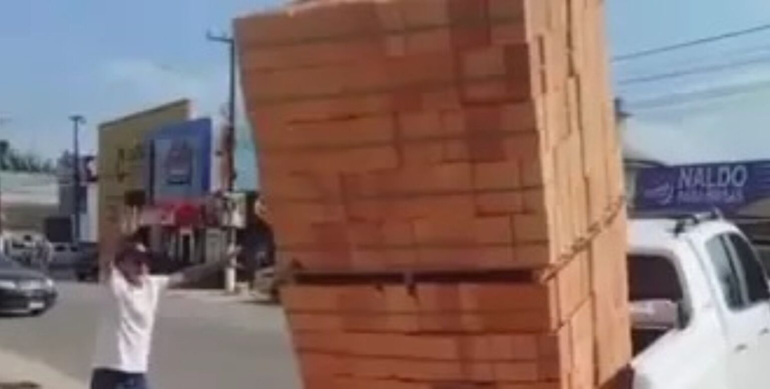 Homem se arrisca e tenta transportar duas pilhas de tijolos em carroceria de caminhonete no Pará